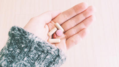 Hand holding variety of pill supplements